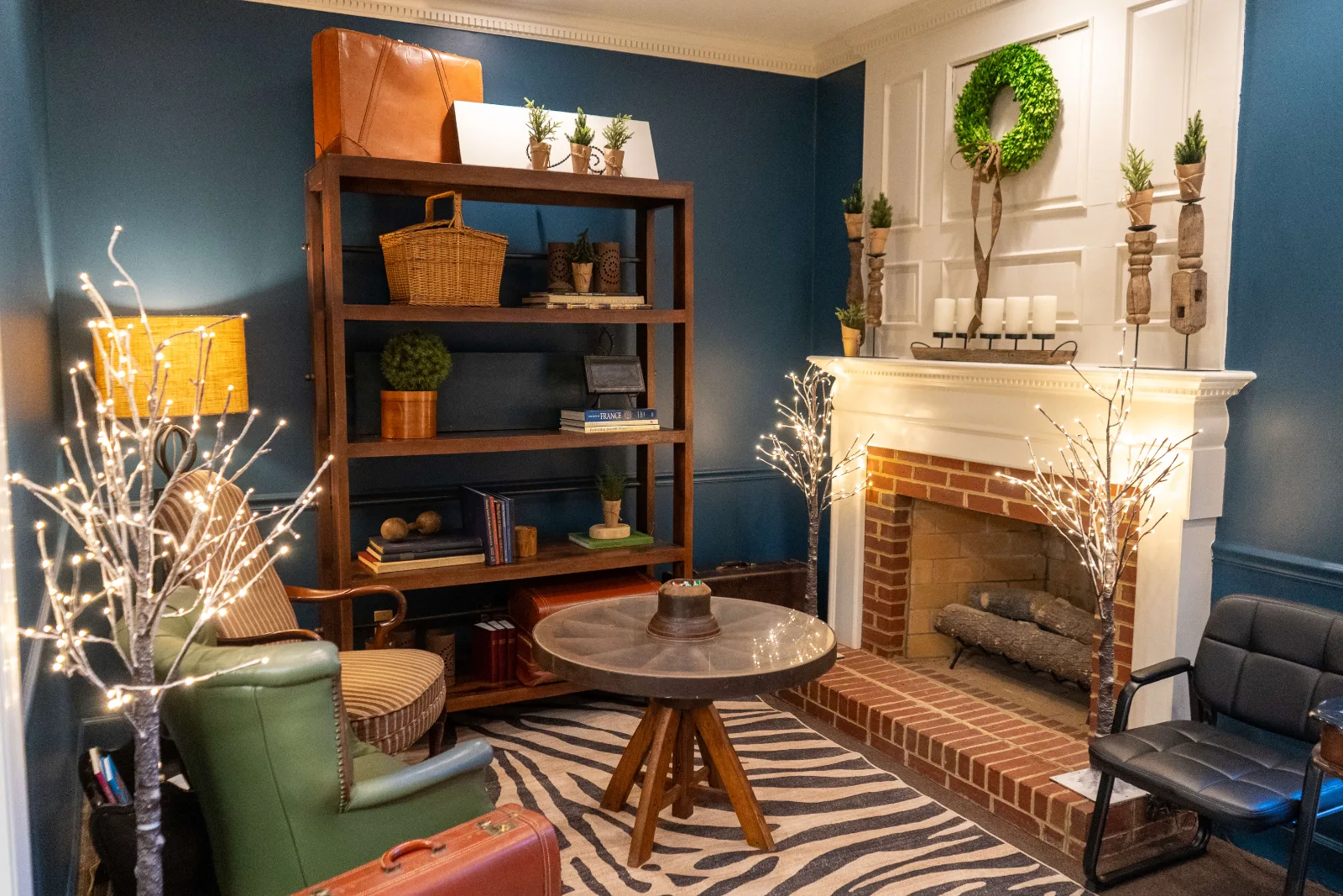 A cozy waiting lounge at Birch Tree Dentistry with a fireplace, bookshelf, and comfortable seating