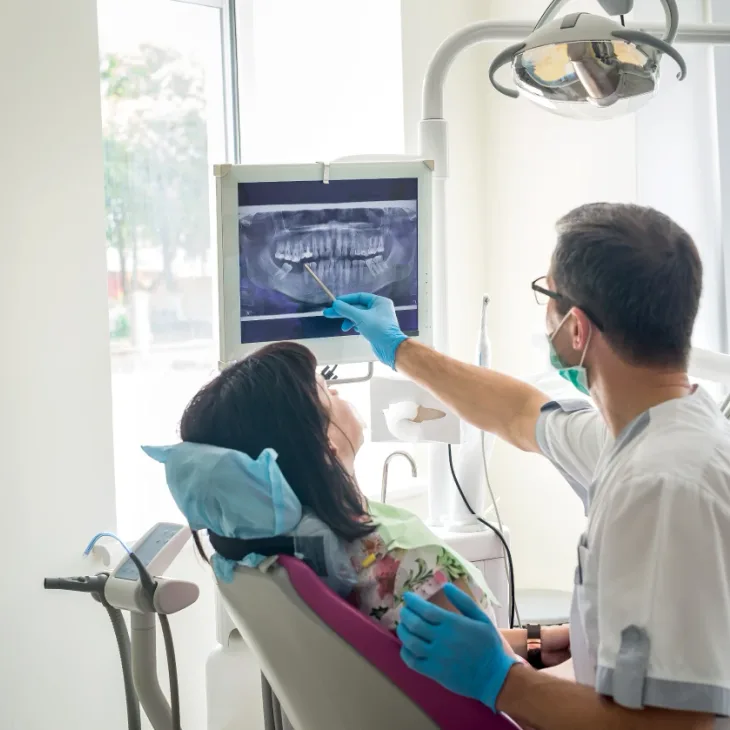 A dentist showing a patient her X-ray on the chairside screen