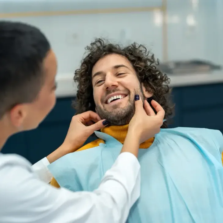 A patient laughing with his dentist during an appointment