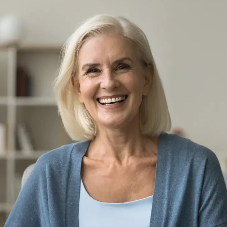 An older woman laughing and smiling at home