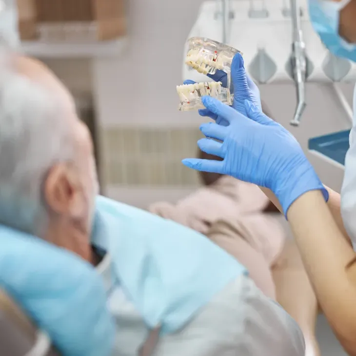 Dr. Bouz showing a patient an implant model