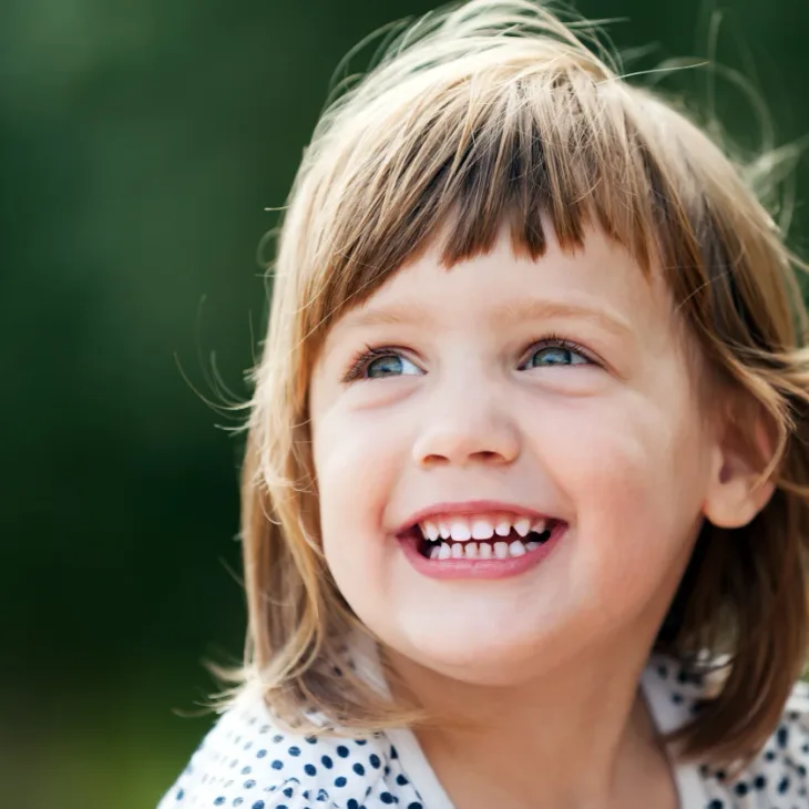 A little girl laughing outdoors