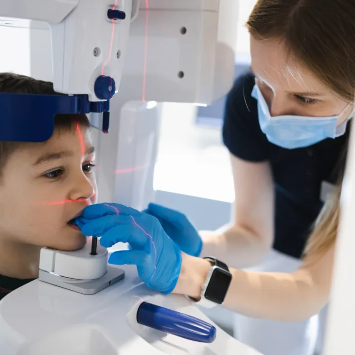 A dental assistant taking an intraoral scan for a child