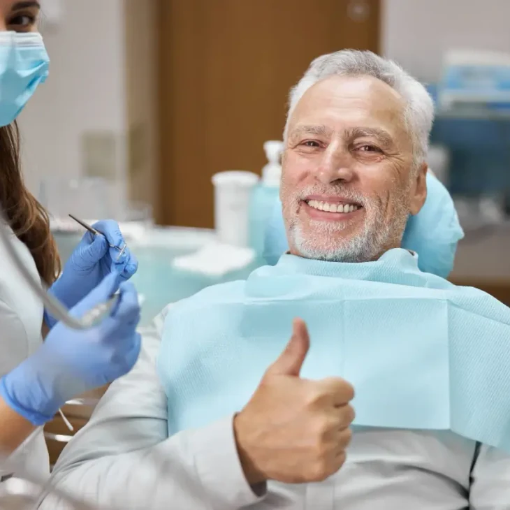 A patient giving a thumbs up from the dental chair during his appointment