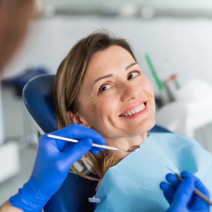 A patient relaxed in the dental chair, smiling during her appointment