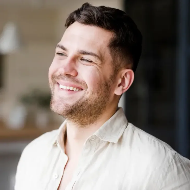 A smiling man outdoors in a light shirt