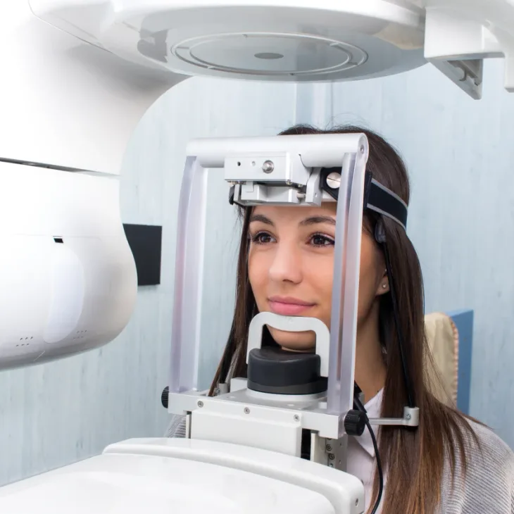 A woman positioned in a panoramic X-ray machine