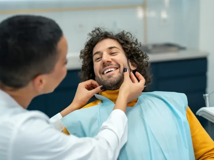 A patient laughing while the dentist examines his jaw